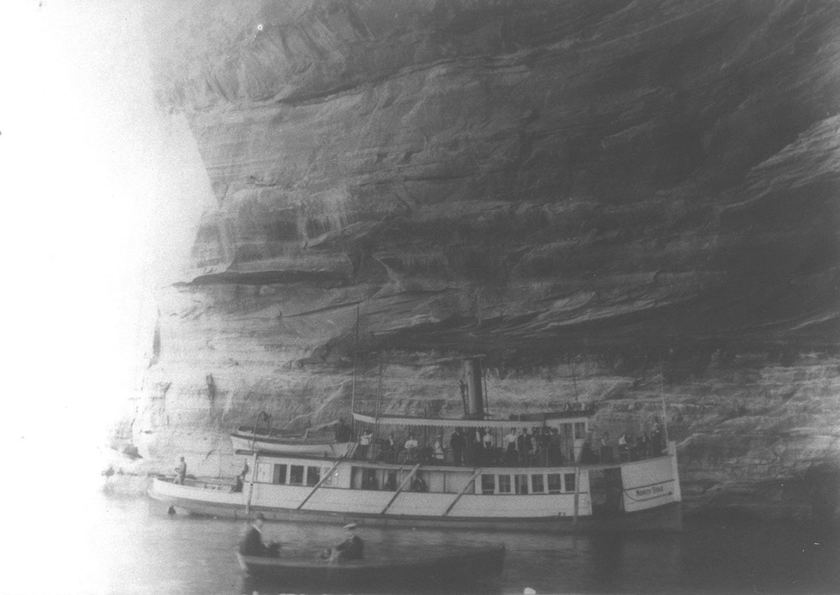 A boat cruises along the Pictured Rocks in the early 1900s. Photo courtesy of the Alger County Historical Society.