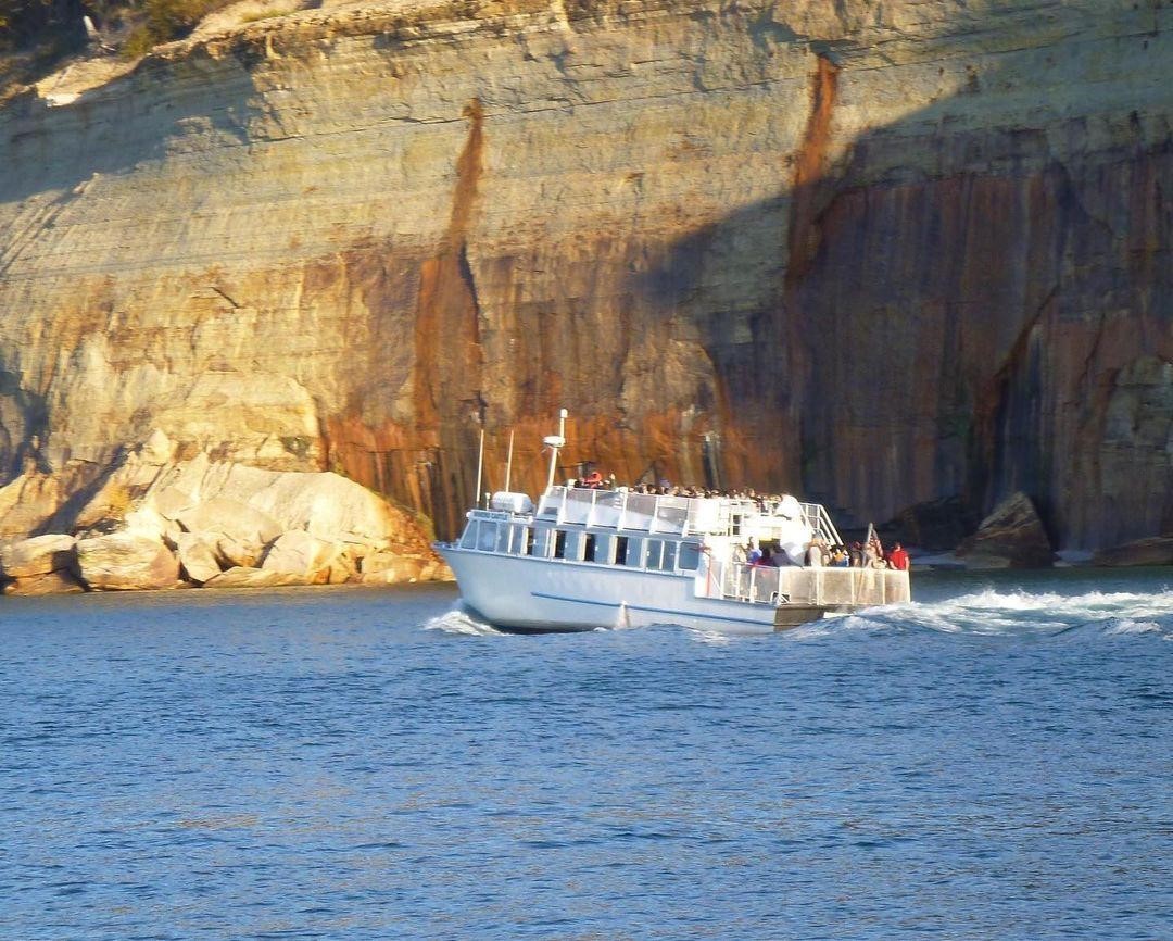 A Pictured Rocks Cruises boat along the cliffs
