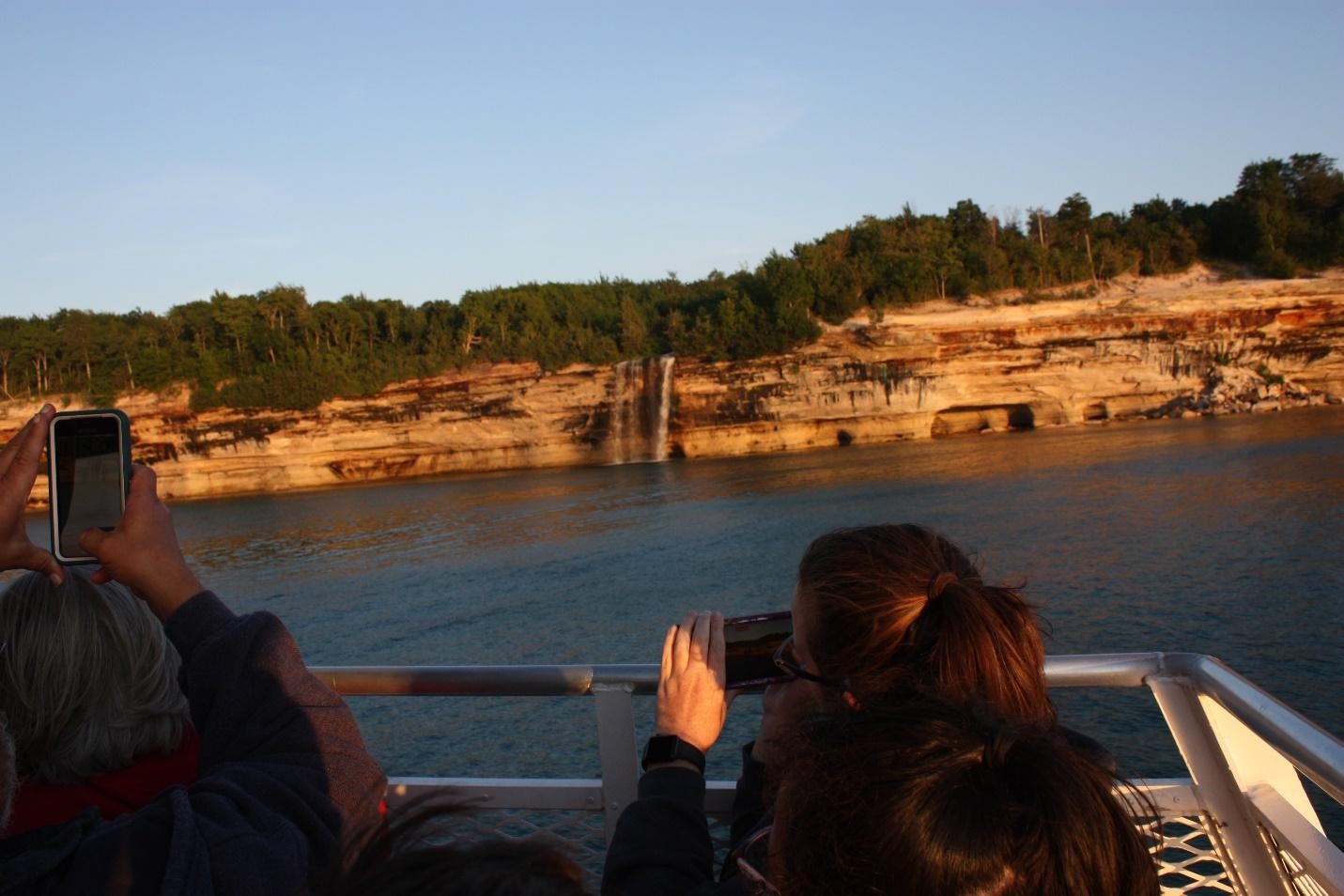 Passengers aboard a Pictured Rocks Cruises boat take photographs of Spray Falls, one of the many landmarks in the park.