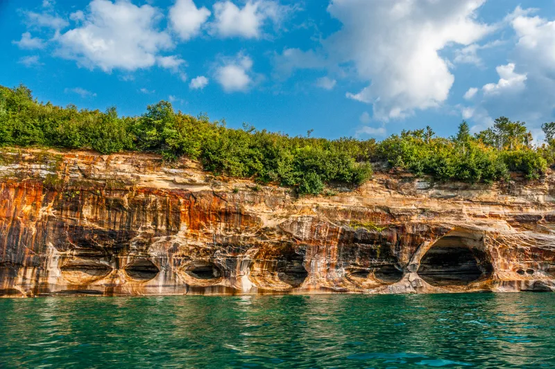 The weaving pattern of mineral stained sea caves, a Pictured Rocks tour highlight, is called Caves of All Colors