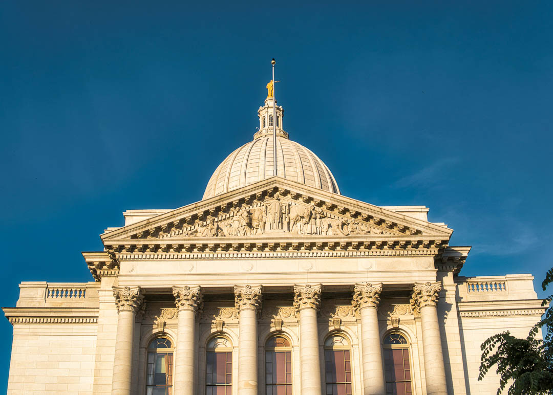 View of Wisconsin State Capitol building's dome against a clear blue sky in Madison.